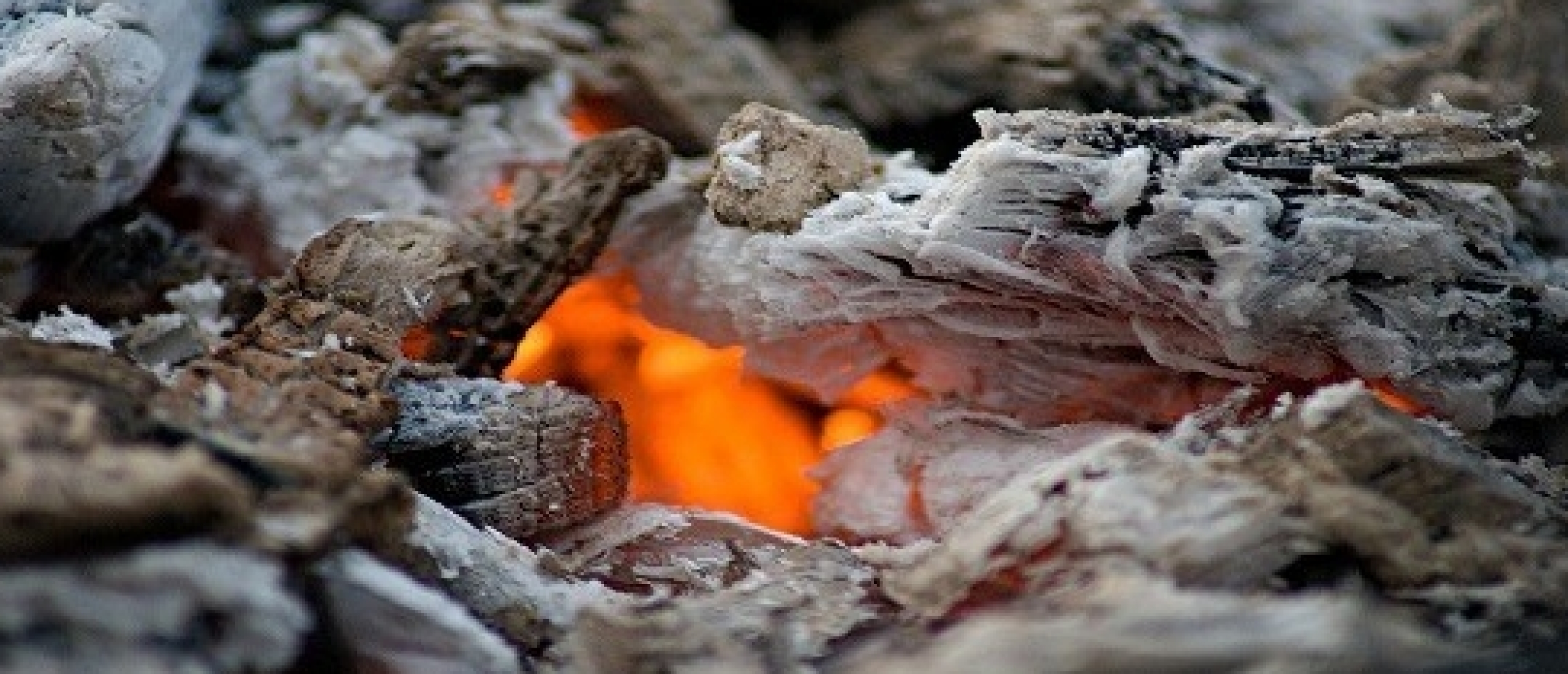 Brandende haard met hout voor haardas in de tuin