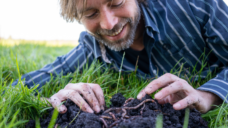 Verse wormencompost in de hand, rijk aan organisch materiaal en actief bodemleven dat bijdraagt aan een gezonde bodem en stabiele grasgroei. Wormencompost in de hand als natuurlijke bron van bodemleven voor gezonde grasgroei.