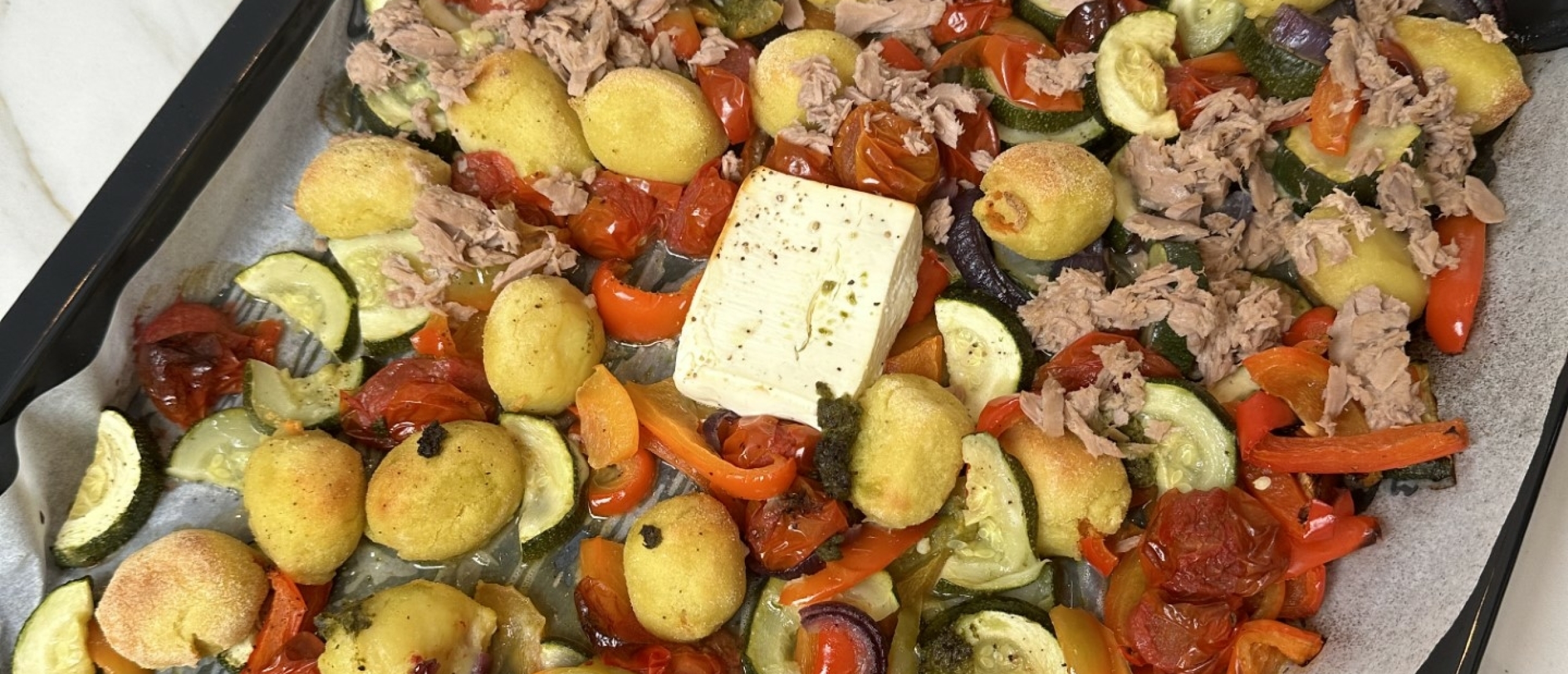 Simpele en eiwitrijke traybake met gnocchi, tonijn, geroosterde groenten, feta en pesto