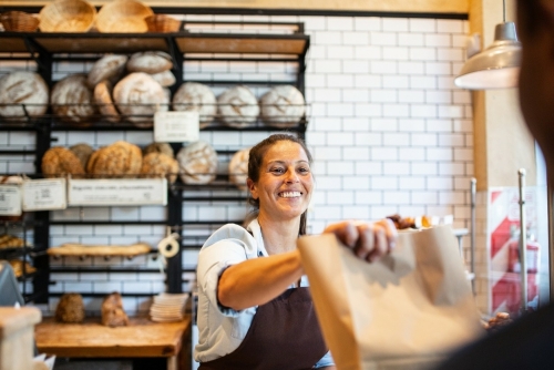 Bakker geeft brood aan klant