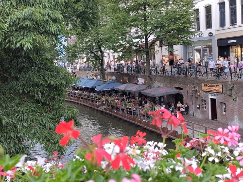 Oudegracht in Utrecht met werf en terras en daarboven winkels