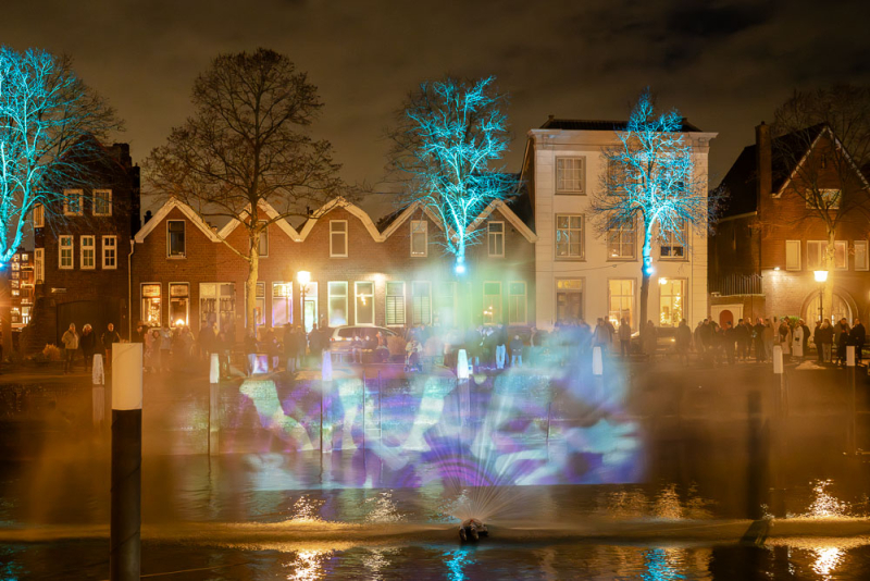 Avondfotografie met lichtshow en reflecties in stadswater