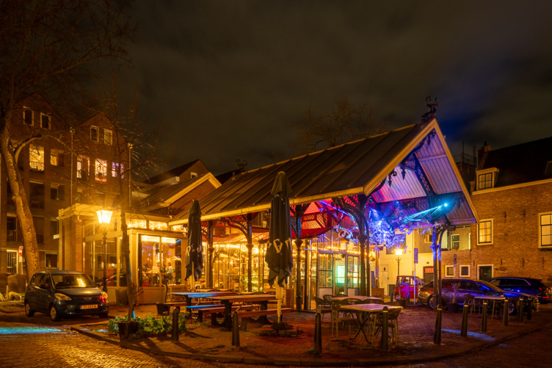 Warme stadssfeer bij nacht - straatfotografie met cafés