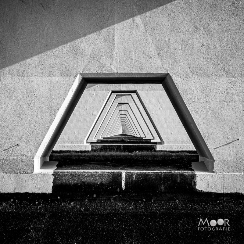 Zwart-wit foto van geometrische architectuur met herhalende lijnen en perspectief, minimalistische compositie met sterke schaduwpartijen