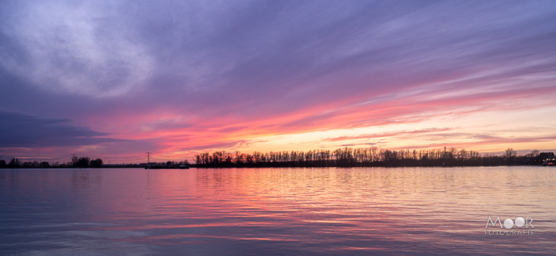 Zonsondergang boven de Merwede met paarse en roze luchtreflectie – voorbeeld van landschapsfotografie tijdens het gouden uur.