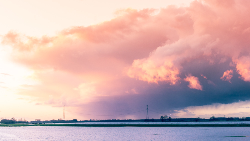 Landschapsfoto met dreigende wolkenlucht boven open water die laat zien hoe perspectief verandert door afstand, standpunt en compositie