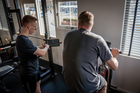 Personal trainer legt iets uit aan sporter