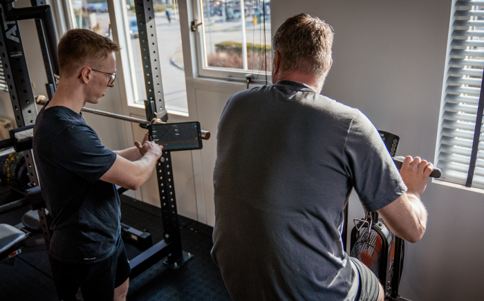 Personal trainer legt iets uit aan sporter