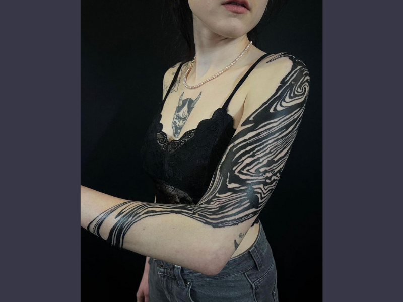 Blackwork tattoo golven op arm