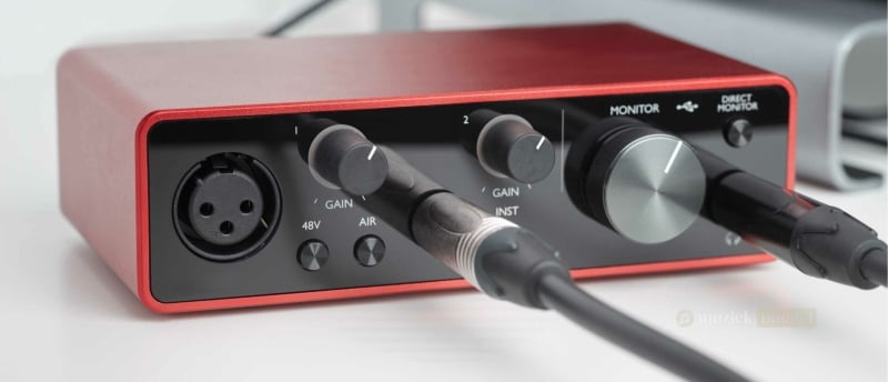 Close-up van een audio interface met aangesloten kabels, essentieel voor muziekproductie en live optredens.