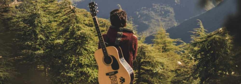 Man met gitaar in bergen