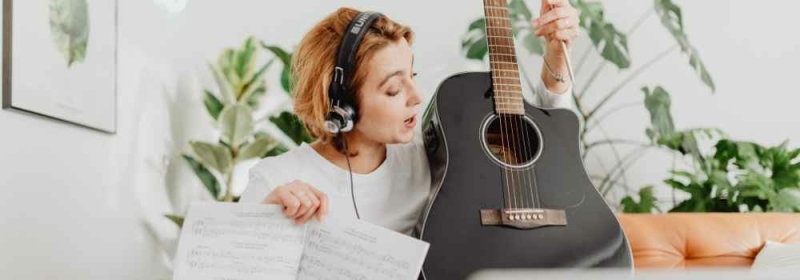 Vrouw leert gitaar spelen