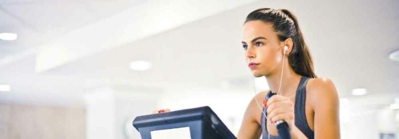 Vrouw met bedrade oordopjes in sportschool