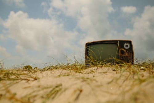 Boven op een zandduin ligt een ouderwetse tv