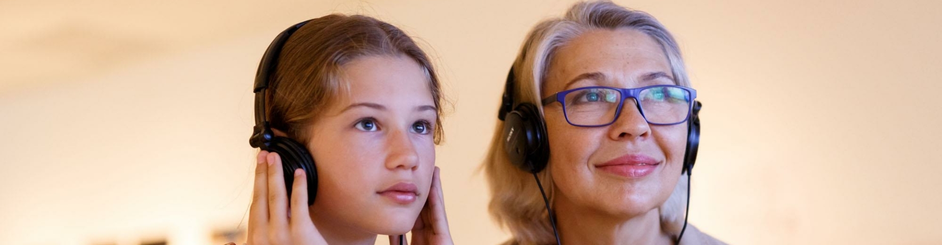 Een vrouw en een meisje gebruiken een audiogids in een museum