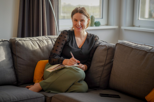 Vrouw op de bank, adviseur voeding, dierlijk eten, boekje in de hand.