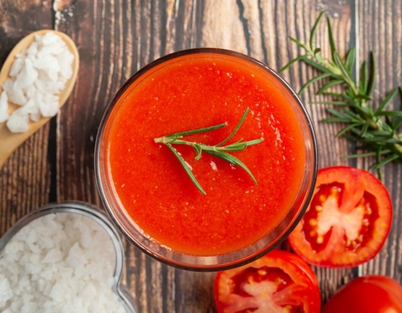 Een smakelijke kom tomatensoep, rijkelijk gevuld en dampend, klaar om te genieten.