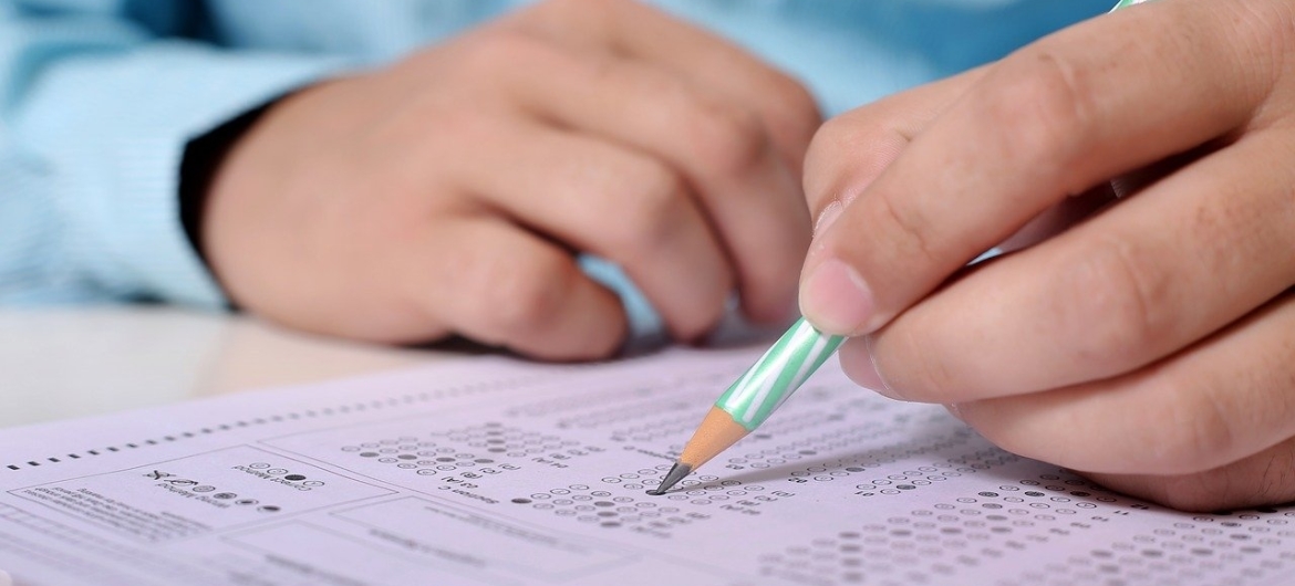 Man vult een examenformulier in met potlood
