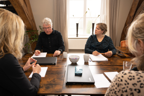 3 vrouwen en 1 man zitten in bespreking