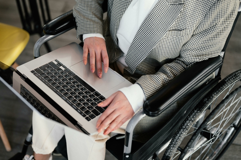 ondernemer of zzp'er aan het werk op de laptop in een rolstoel
