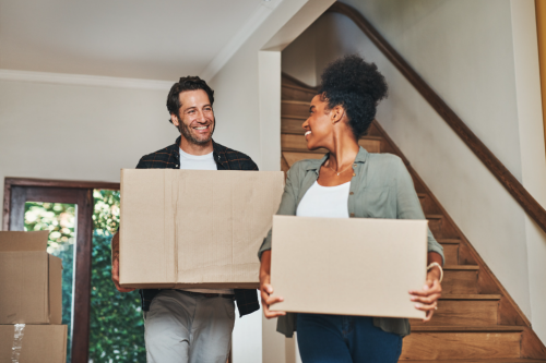 Een man en een vrouw die intrekken in hun nieuwe woning na hun aankoop.