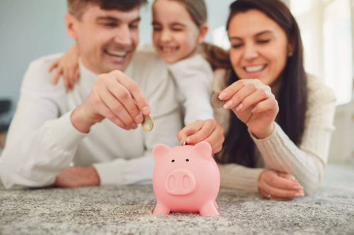 een gezin dat geld in een spaarvarken steekt