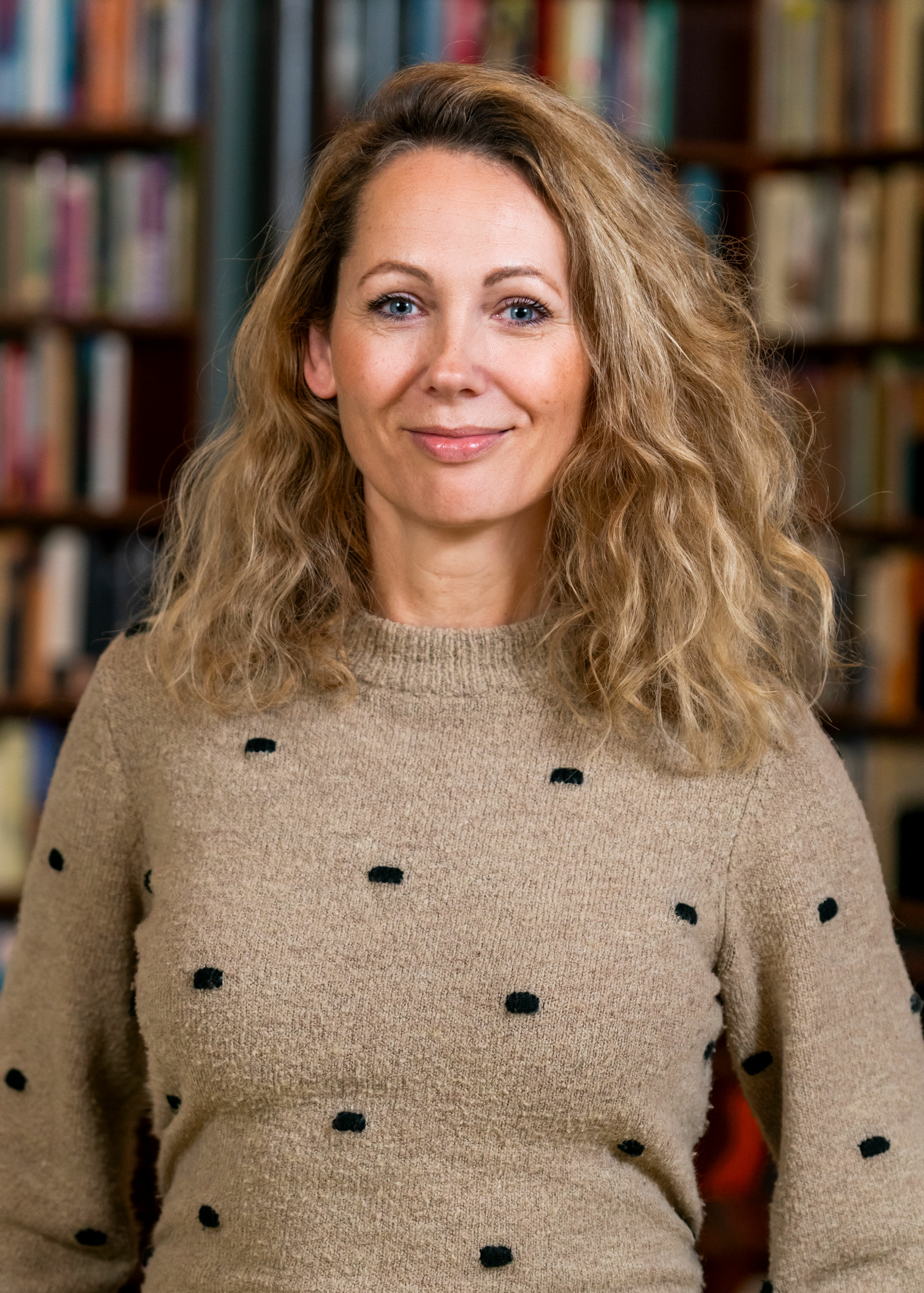 Lotte Boot poseert voor een boekenkast