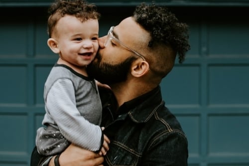 man geeft zoontje een kus