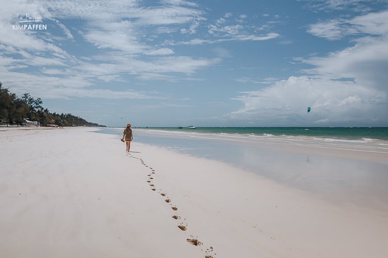 Women walking on white sandy beach of Diani Beach looking at Turquoise water of the Indian Ocean
