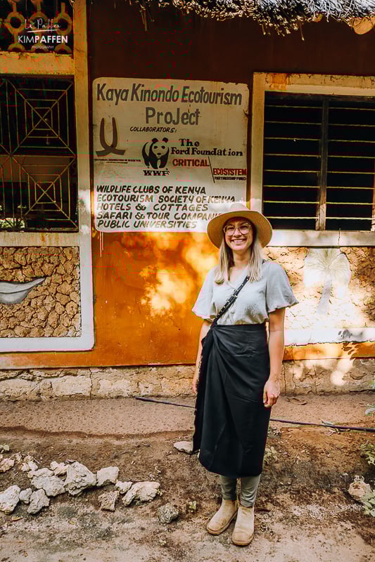 Woman standing in front of the entrance of Kaya Kinondo Eco Tourism Project