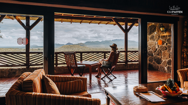 woman sitting on private verandah of the luxury suite from Serena Kilaguni Safari Lodge Kenya, enjoying the views of the Chyulu Hills and Mt. Kilimanjaro