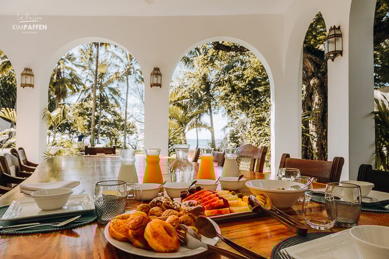 Tropical breakfast spread with pastries, fruit, and fresh juice