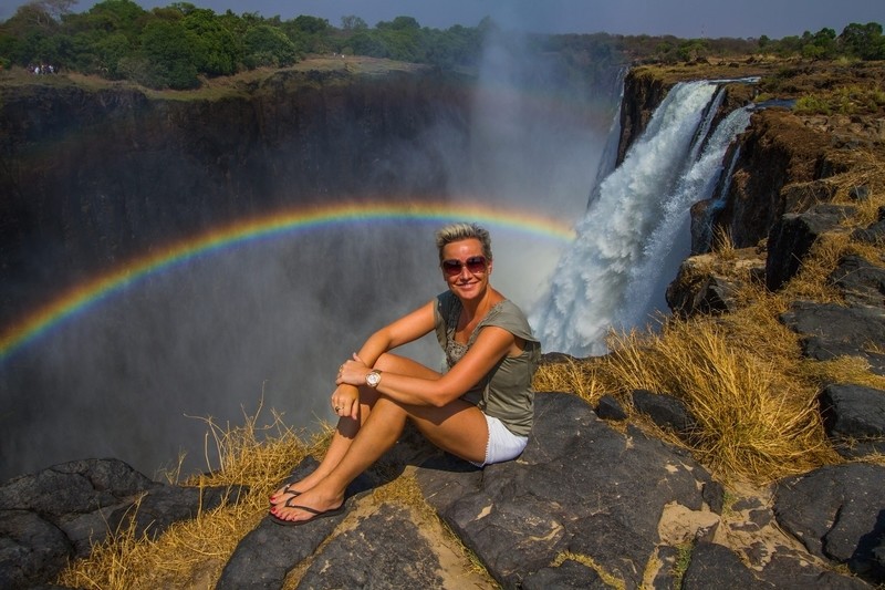 In front of the mighty Victoria Falls in Zambia with a perfect rainbow