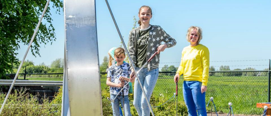 Blij midgetgolfspelers, moeder met kinderen, op de crazygolfbaan met de megalooping