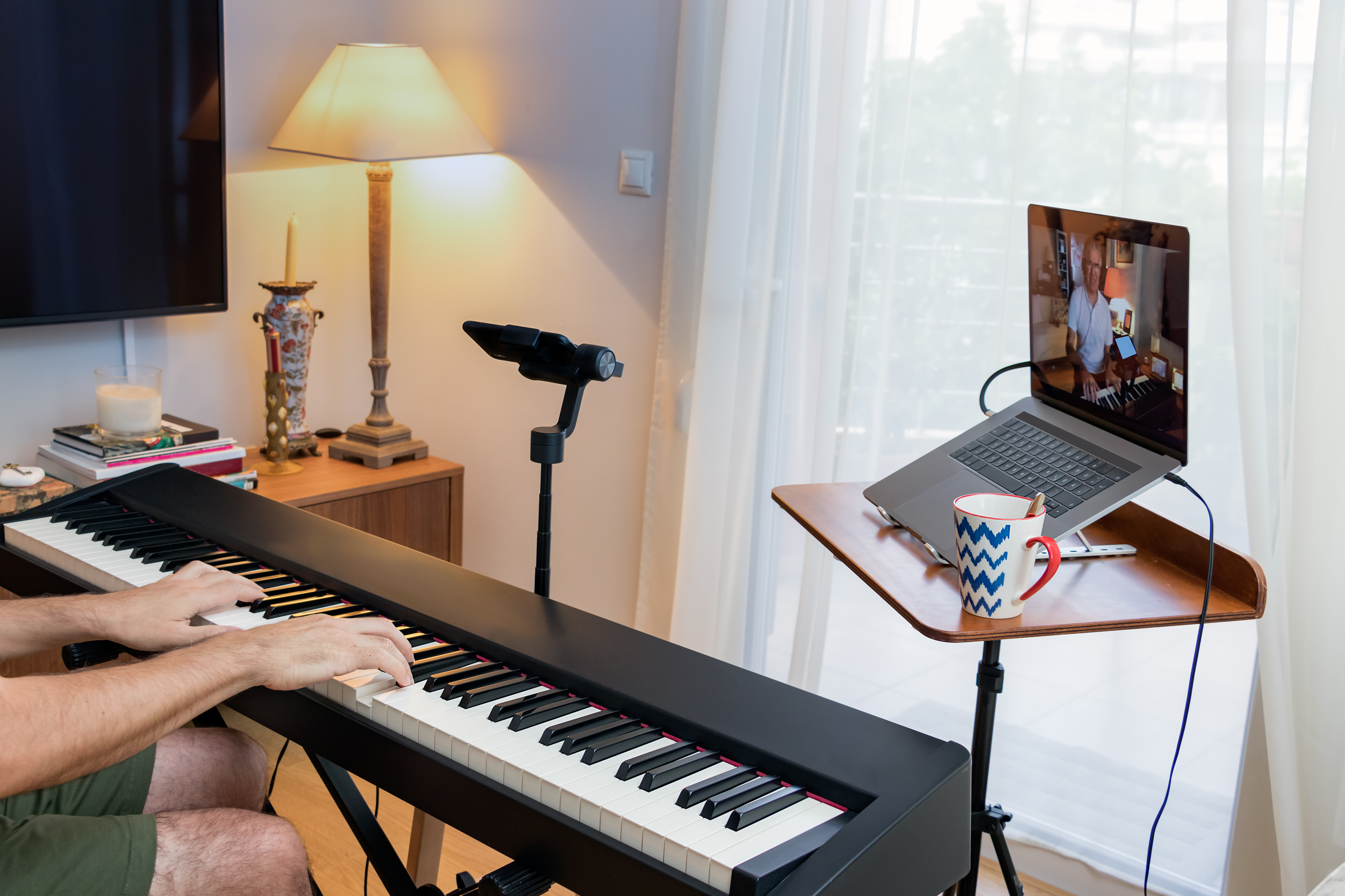 afbeelding van iemand die online pianolessen volgt of een cursus in een verlichte kamer op een digitale piano