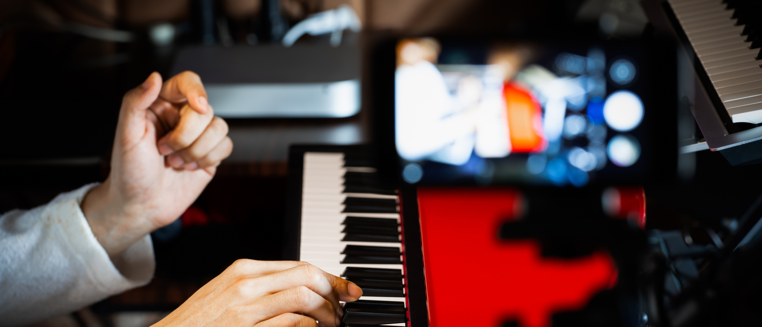 afbeelding van persoon die via  het internet piano leert spelen