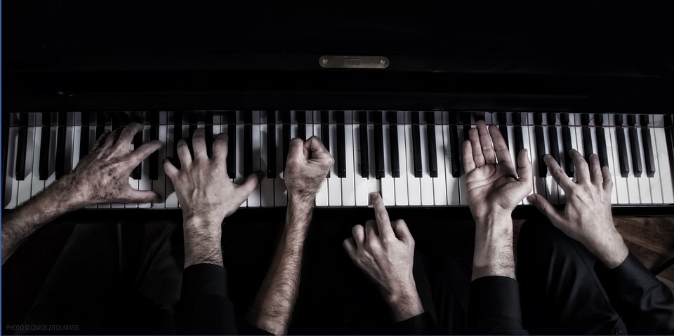 meerdere handen op pianoklavier