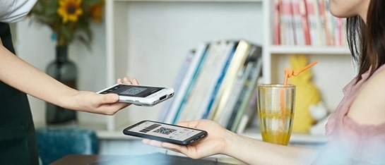 Iemand die een QR code scant met de CCV Compact A77C die je kan huren bij PinDirect