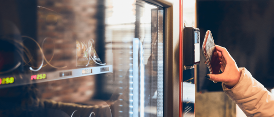 Iemand die een contactloze betaling doet op een CCV IM30 onbemande pinautomaat