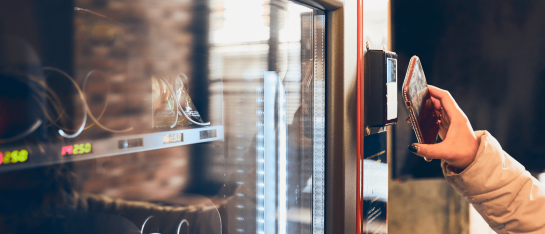 Iemand die een contactloze betaling doet op een CCV IM30 onbemande pinautomaat