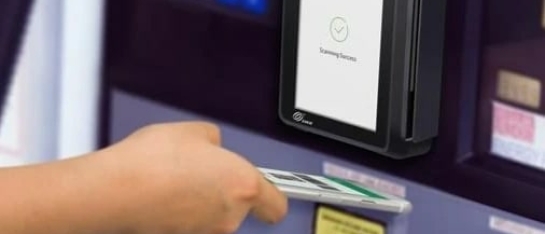 Iemand die een contactloze betaling doet op een CCV IM30 onbemande pinautomaat met een mobiele telefoon