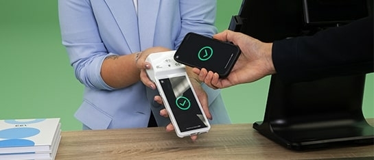 Iemand die een contactloze betaling doet op een CCV Plus Mobile A960 die je kan kopen bij PinDirect