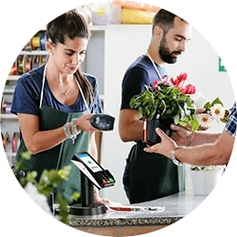 Iemand die een bosje bloemen afrekent bij een bloemist die gebruik gemaakt van de CCV Nexus Pad A35 vaste pinautomaat. Deze vaste pinautomaat kan u kopen bij PinDirect