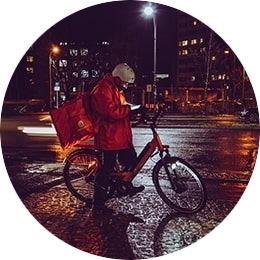 Iemand die met een thuisbezorgd fiets buiten staat met een pinautomaat voor thuisbezorging en afhalen