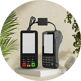 De CCV Duo Base A80-A35 op een wit platform omringt door planten. U kan deze vaste pinautomaat kopen bij PinDirect