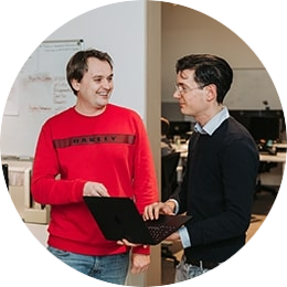 Twee personen die samenwerken op een laptop