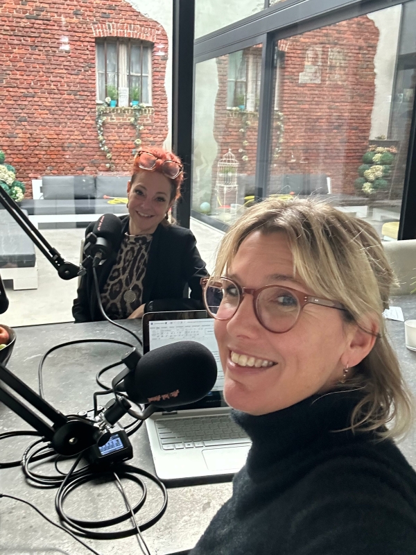 Twee vrouwen achter microfoons nemen een podcast op
