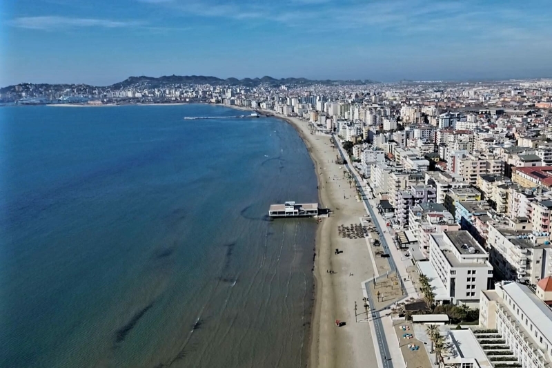 Wide sandy beach in Durrës, Albania, overlooking the Adriatic Sea on a sunny summer day.