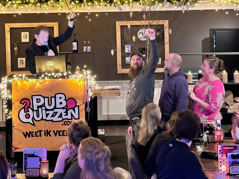 Quizmaster tijdens een compleet verzorgde pubquiz op locatie met het winnende team