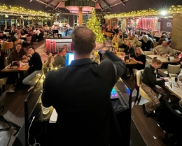 Quizmaster presenteert een pubquiz op locatie voor een volle zaal